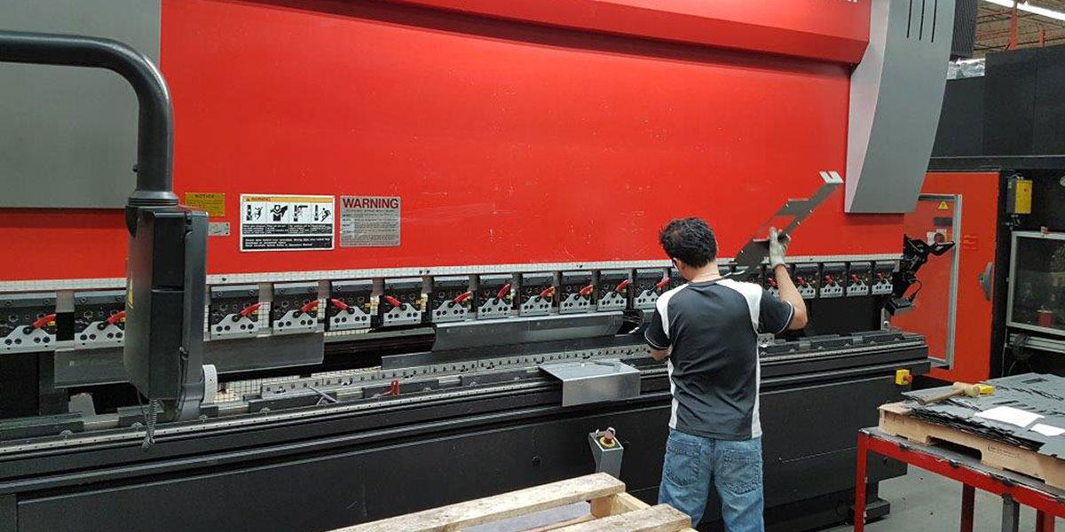Image of a Dana Precision employee operating a Custom Metal Fabrication machine.